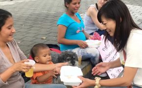 Yoriko gives a meal to a Venezuelan family in Medellin Colombia
