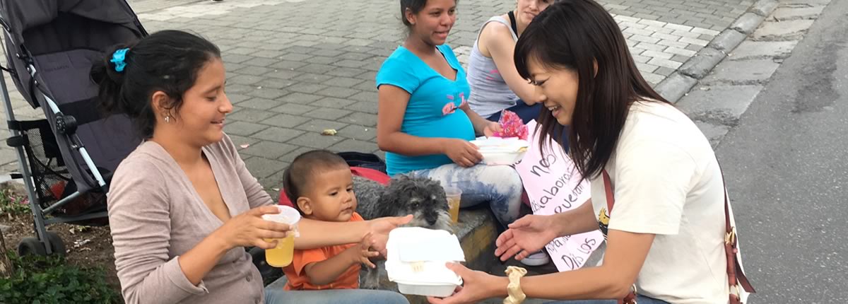 Yoriko gives a meal to a Venezuelan family in Medellin Colombia