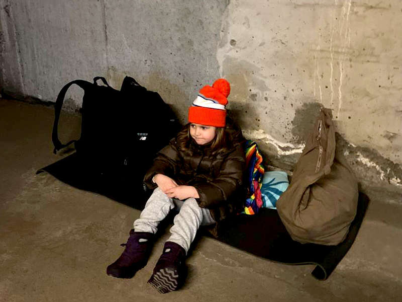 child takes cover in a bomb shelter in Kyiv