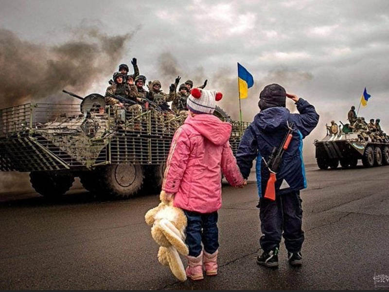 Children wave to soldiers